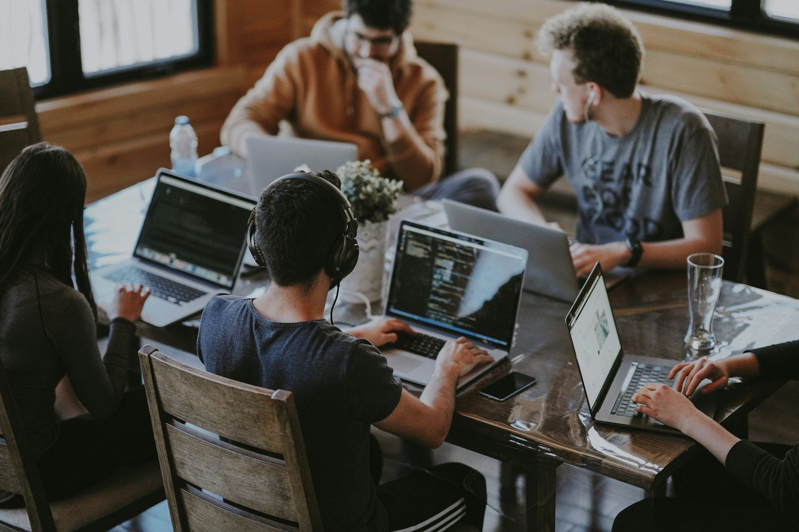 Software engineering team collaborating on workstation laptops in an open development office