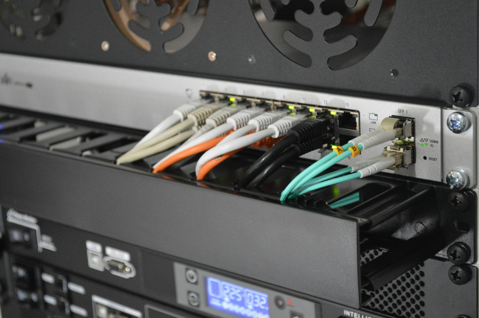 Illuminated server blades and high-speed interconnect cables inside a dense AI accelerator compute cluster.