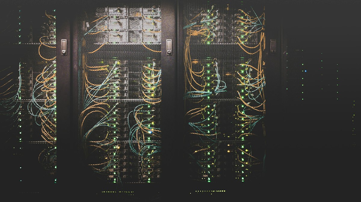 Aerial perspective of hyperscale data center facility with industrial cooling towers, power substations, and water retention systems